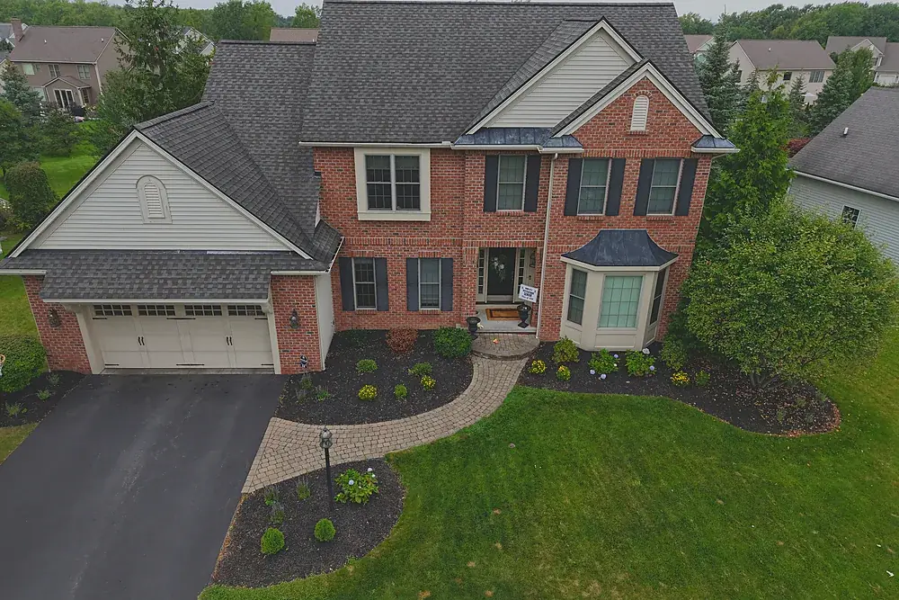 Aerial photograph of a brick colonial home and driveway in a Rochester, New York suburb
