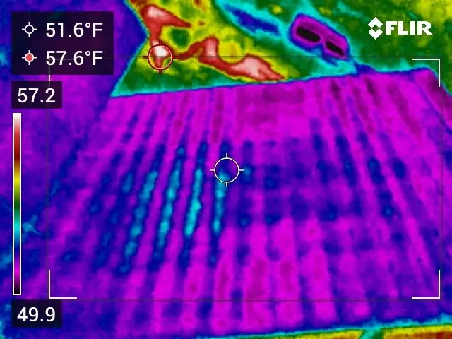 Night thermal image of a pitched shingle roof showing heat moving through the roof framing
